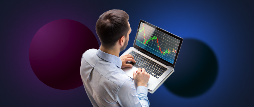 A man focused on a laptop showing a stock chart, illustrating the journey of a trader choosing his trading style and technique.